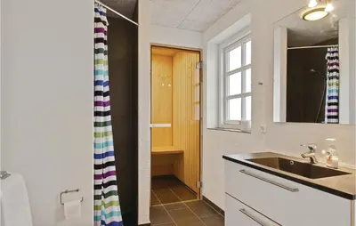 a bathroom with a sink and a window at Holiday Home Doblervej Harboøre Denm in Harboør