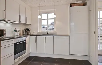 a white kitchen with white cabinets and a sink at Holiday Home Doblervej Harboøre Denm in Harboør