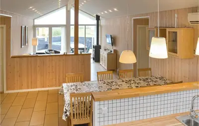 a kitchen and dining room with a table and chairs at Frk Lyng in Harboør