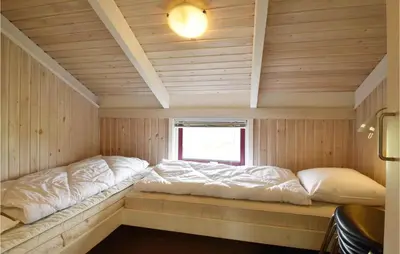 a room with two beds in a wooden cabin at Holiday Home Arcticvej Harboøre Iv in Harboør