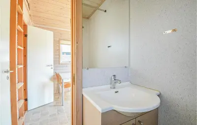 a bathroom with a sink and a mirror at Hytte 6 in Thyborøn