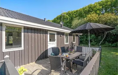 a patio with a table and an umbrella at Fjordglimt in Vestervig