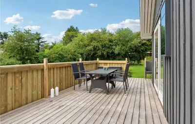 a wooden deck with a table and chairs on it at Fjordglimt in Vestervig