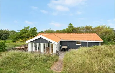 a house with an orange roof sitting on top of a hill at Holiday Home Kristinesvej Xii in Thisted