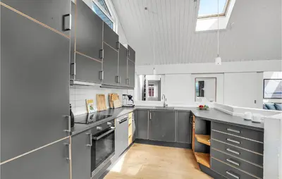 a kitchen with stainless steel appliances and a large window at Stunning Home In Thisted With Sauna in Thisted