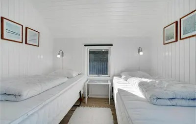 a white room with two beds and a window at Åbo in Thisted
