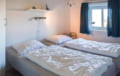two unmade beds in a bedroom with a window at Nice Home In Thisted With Sauna in Thisted