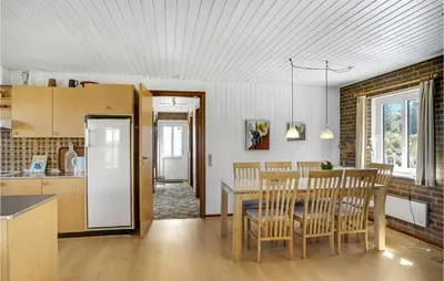a kitchen and dining room with a table and chairs at Holiday Home Clemmessti in Thisted