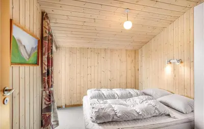 a bed in a room with wooden walls at Holiday Home Hannesvej V in Vestervig