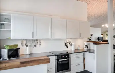 a white kitchen with white cabinets and a microwave at Holiday Home Hellesvej Vestervig Denm in Vestervig