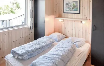 two beds in a room with a window at Holiday Home Søtungevej in Thisted