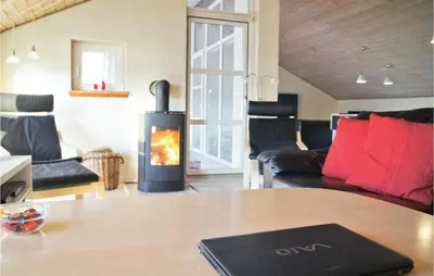 a living room with a fireplace and a table at Holiday Home Klitstien Ii in Thisted