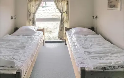 two beds in a room with a window at Holiday Home Klitstien Ii in Thisted