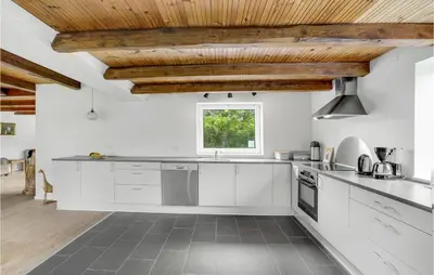 a kitchen with white cabinets and wooden ceilings at Holiday Home Årup Byvej in Snedsted