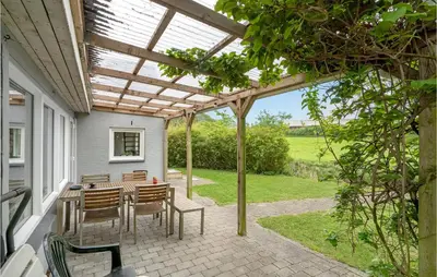 a patio with a table and chairs under a pergola at Holiday Home Årup Byvej in Snedsted