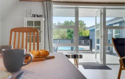 a table with a cup of coffee and a view of a patio at Nice Home In Vestervig With Wifi in Vestervig