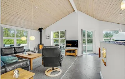 a living room with a couch and a chair at Holiday Home Kristinesvej Thisted Vi in Thisted