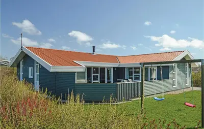 a blue house with a red roof in a yard at Stunning Home In Vestervig With Sauna in Vestervig