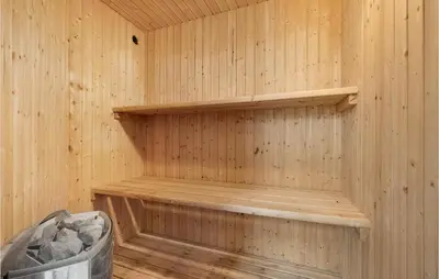 a wooden interior of a sauna with a bench in it at 4 Bedroom Lovely Home In Vestervig in Vestervig