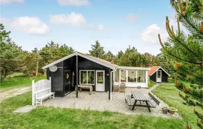 a black and white tiny house with a bench at Holiday Home Mølgårdsvej Thisted in Thisted