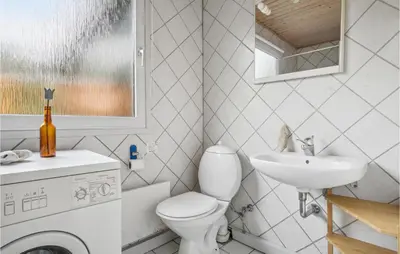 a bathroom with a washing machine and a sink at Holiday Home Mølgårdsvej Thisted in Thisted