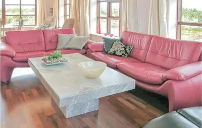 a living room with pink couches and a coffee table at Casa Blanca in Thisted
