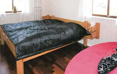 a bed with a black comforter on it in a room at Casa Blanca in Thisted
