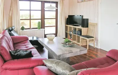 a living room with two red chairs and a table at Casa Blanca in Thisted