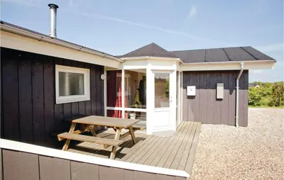 a house with a picnic table on a deck at Stunning Home In Vestervig With Sauna in Vestervig