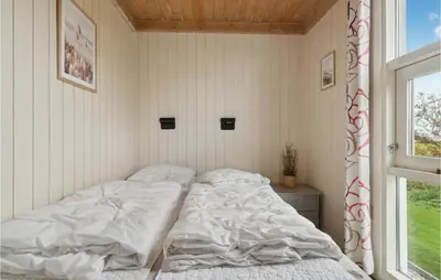 an unmade bed in a room with a window at Stunning Home In Vestervig With Sauna in Vestervig