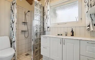 a bathroom with a shower and a toilet and a sink at Stunning Home In Vestervig With Sauna in Vestervig