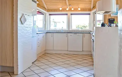 a kitchen with white cabinets and a tile floor at Stunning Home In Thisted With Sauna in Thisted