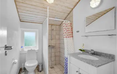 a bathroom with a toilet and a sink and a shower at Beautiful Home In Vestervig With Sauna in Vestervig