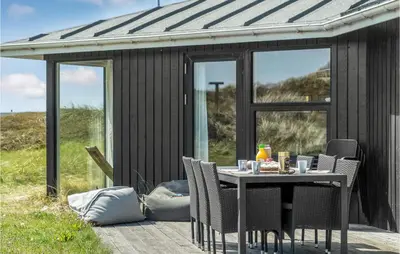 a table and chairs in front of a black shed at Stunning Home In Thisted With Sauna in Thisted