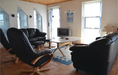 a living room with black leather chairs and a table at Awesome Home In Thisted With Sauna in Thisted