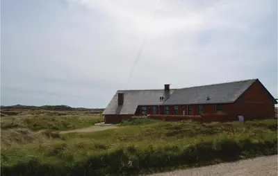 a red barn in the middle of a field at Awesome Home In Thisted With Sauna in Thisted