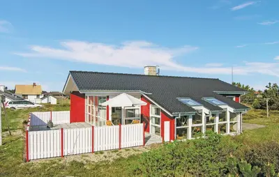a red house with a white fence in front of it at Three-Bedroom Holiday Home In Thisted in Thisted