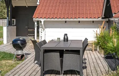 a table and chairs on a deck with a grill at Three-Bedroom Holiday Home In Thisted in Thisted