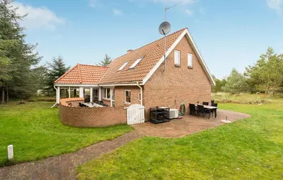 a small brick house with a table in a yard at Four-Bedroom Holiday Home In Thisted in Thisted