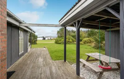 a porch with a swing and a picnic table at Holiday Home Klemsvej in Thisted