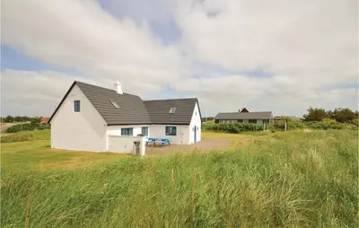 a white house in the middle of a field at Holiday Home Grønkærvej in Thisted