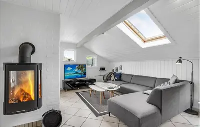 a living room with a couch and a fireplace at Holiday Home Fiskervej Thisted Iv in Thisted