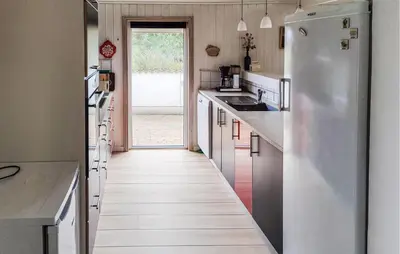 a kitchen with a long hallway with a refrigerator at Holiday Home Ørredvej Thisted Ii in Thisted