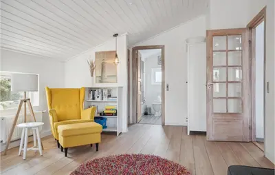 a living room with a yellow chair and a table at Holiday Home Ørredvej Thisted Ii in Thisted