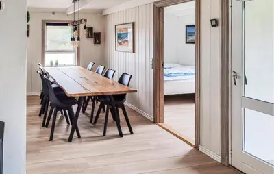 a dining room with a table and chairs and a mirror at Holiday Home Ørredvej Thisted Ii in Thisted