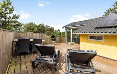 a deck with chairs and a table and a fence at Holiday Home Tranebærvej Thisted Iv in Nørre Vorupør