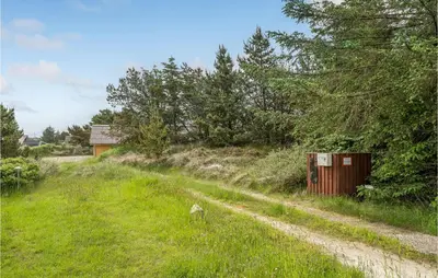 a dirt road in a field with trees and a building at Holiday Home Tranebærvej Thisted Iv in Nørre Vorupør