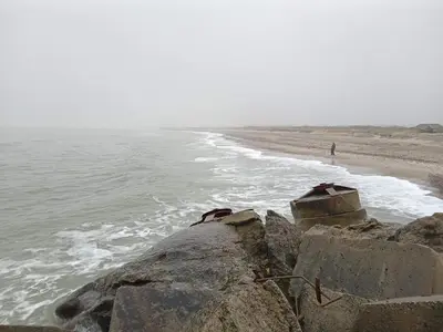a person walking on the beach next to the ocean at Charming Cottage near Beach - By Traum Ferienwohnungen in Fjerritslev