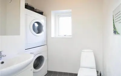 a white laundry room with a washer and dryer at Holiday Home Gunhildsvej Vestervig Xi in Vestervig