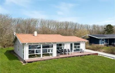 a house with a deck in the grass at Stunning Home In Vestervig With Wifi in Vestervig